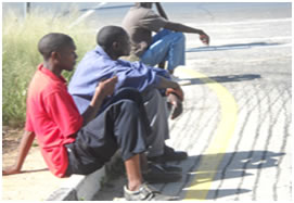 Men Wiaitng on the Side of the Road
